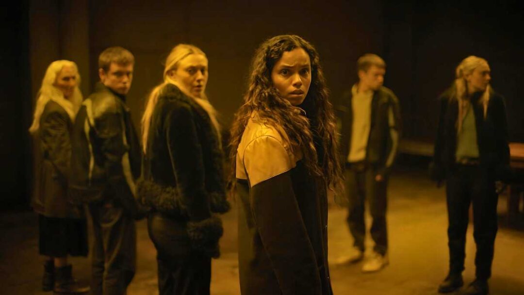 adegan tokoh di film the watchers berdiri di depan kaca